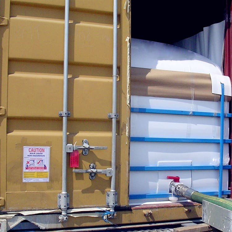 A flexitank being filled with liquid, showcasing the loading process in a warehouse setting.